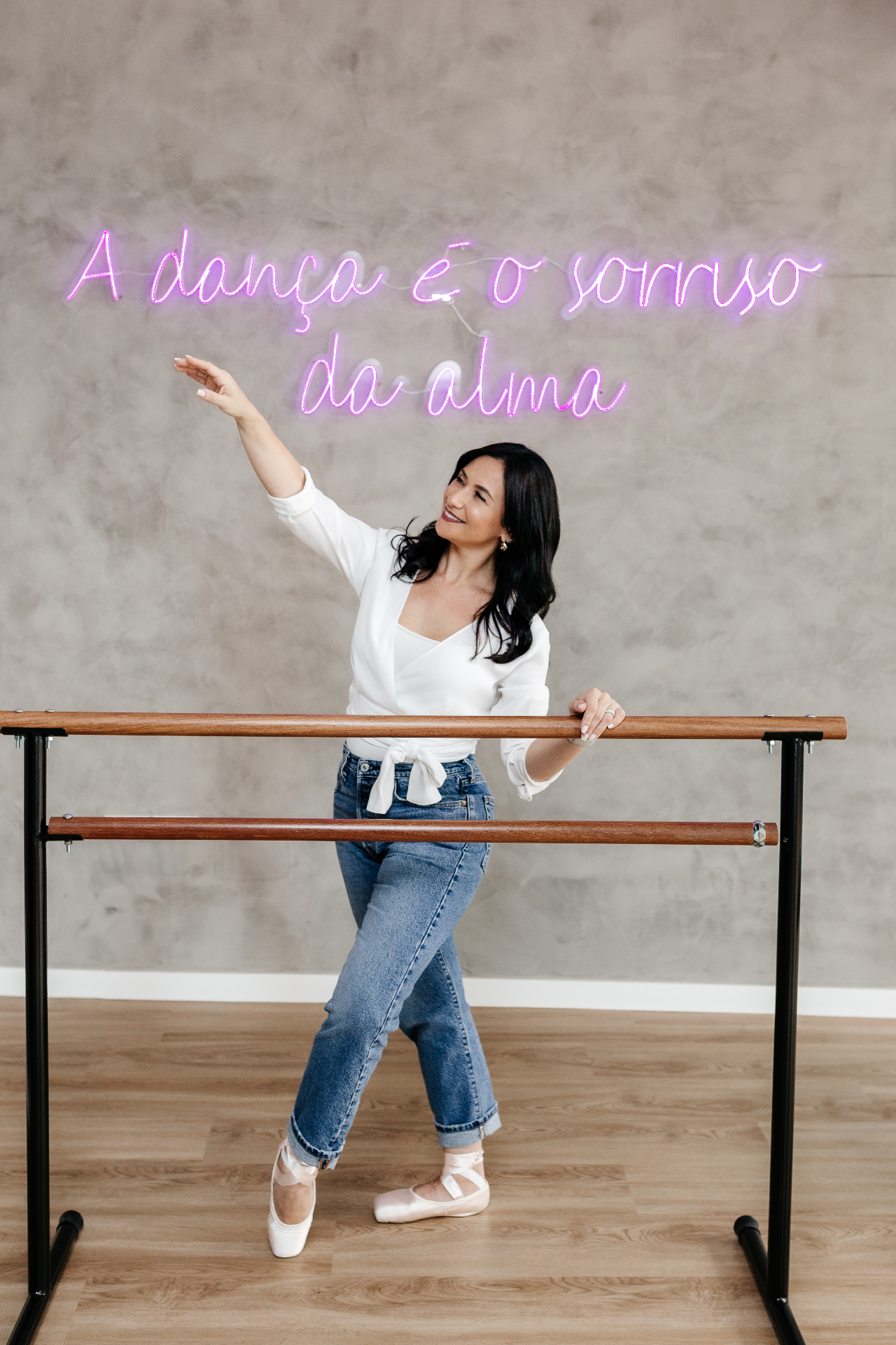 Lilian Sanada em estúdio de dança com neon 'A dança é o sorriso da alma'